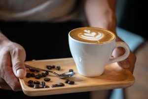 latte and coffee beans on tray