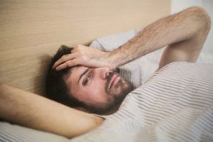 woman with headache in bed